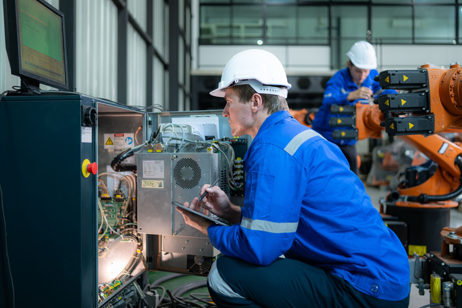 Técnico que trabaja en el gabinete de control eléctrico del brazo robótico, Antecedentes industriales de brazos robóticos